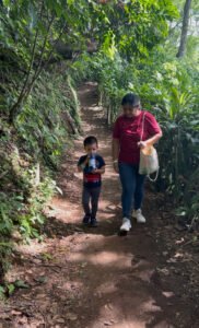 Family walking down a forest trail at FURESA with water bottles