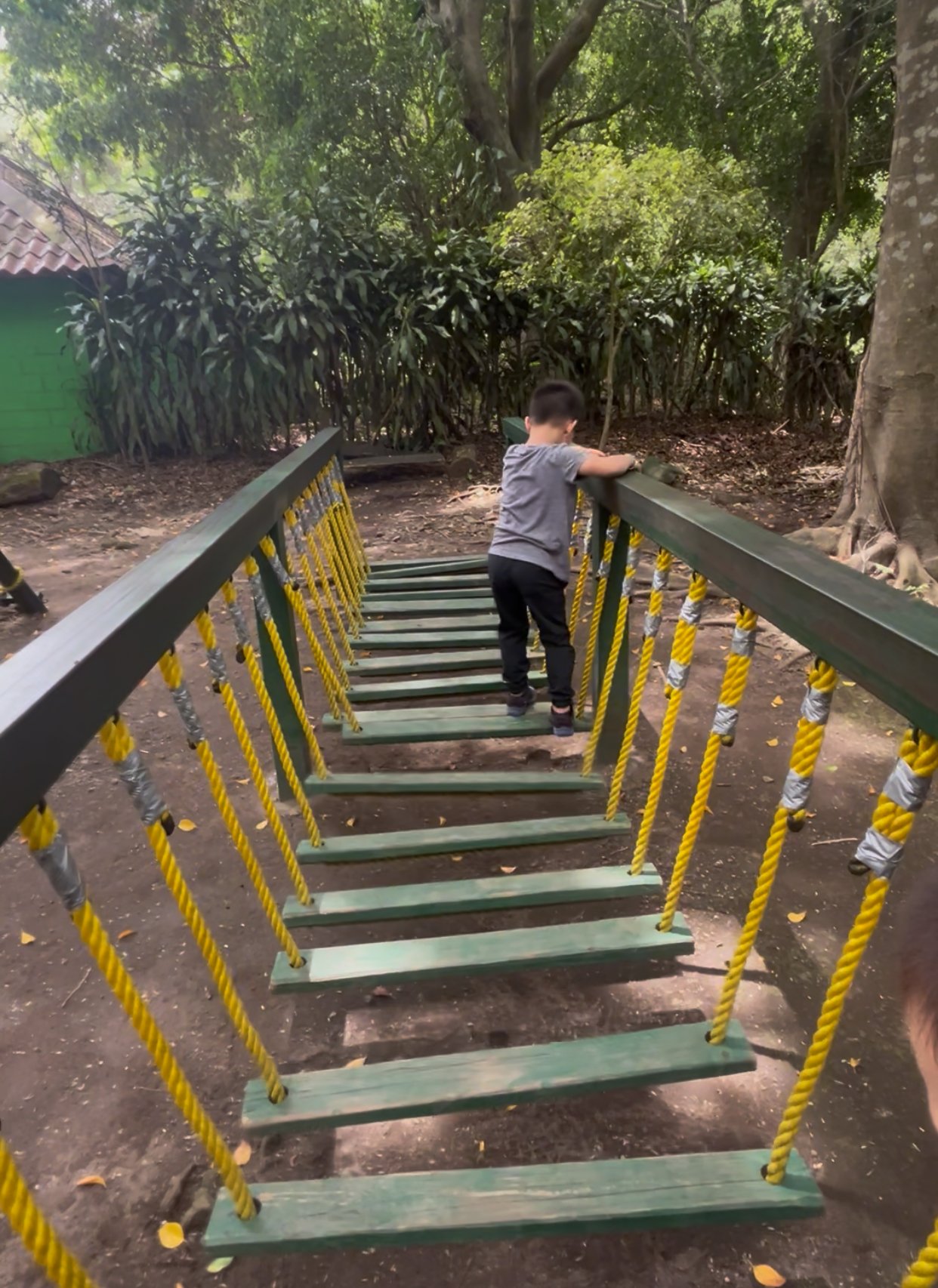 Child crossing a rope bridge play structure at FURESA